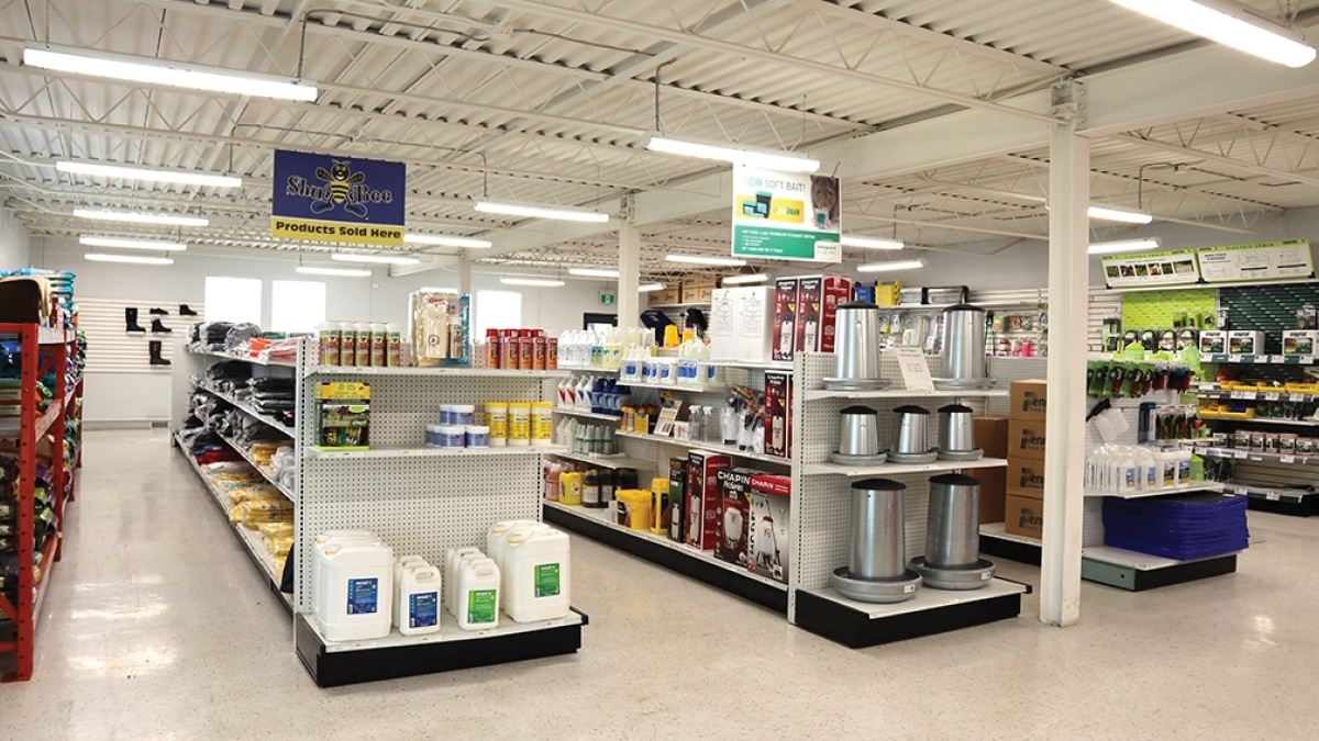 A well-organized store aisle displaying agricultural and industrial supplies such as cleaners, protective equipment, and tools.